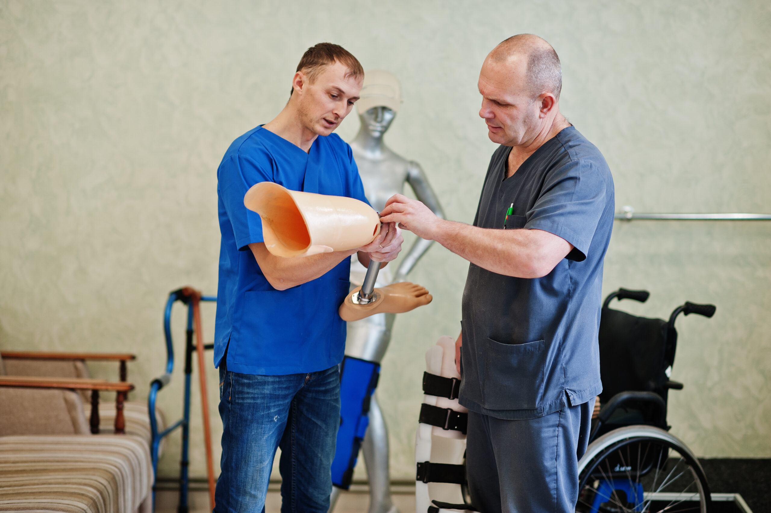 Two prosthetist man workers with prosthetic leg working in labor
